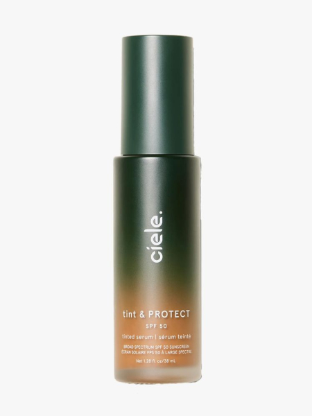 Bottle of Ciele Tint & Protect Serum Foundation SPF 50 with green cap on light gray background