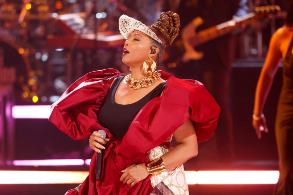Queen Latifah performing in a red puffy robe and tiara